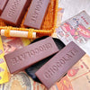 Chocolate squishy bars embossed with 'CHOCOLATE' on a newspaper background