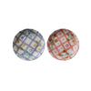 Two decorative plates with floral and checkered patterns on a white background