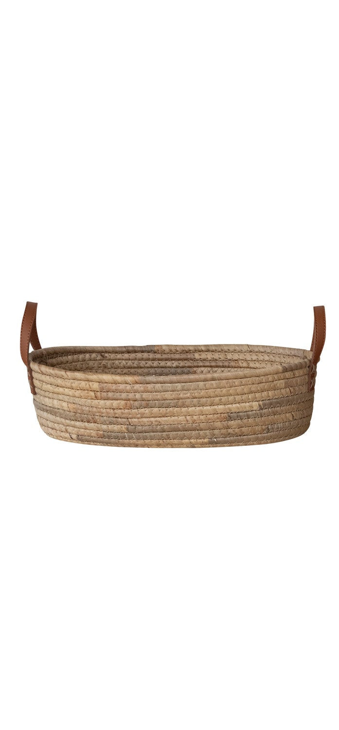 Woven basket with leather handles on a white background
