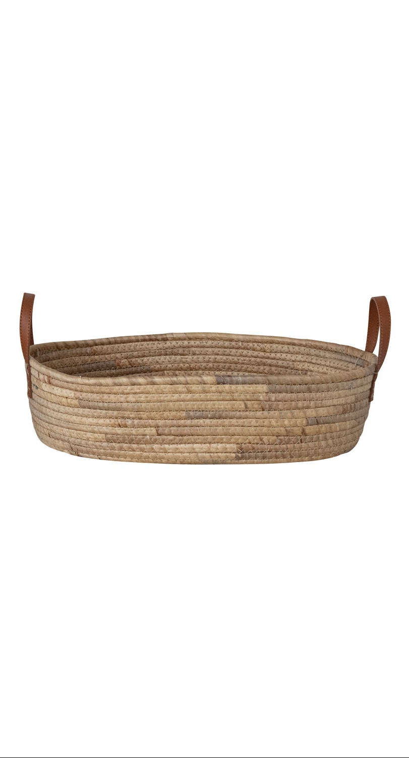 Woven basket with leather handles on a white background