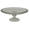 Decorative glass cake stand with intricate design on a white background