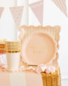 Decorative basket with 'Welcome Baby' sign and party supplies on a light background