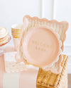 Pink 'Welcome Baby' plate in a basket with other baby shower items.