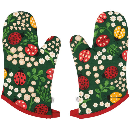 Pair of oven mitts with ladybug and floral pattern on a green background