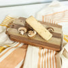Cheese and mushrooms on a wooden cheese board with a striped cloth background