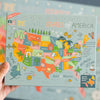 Puzzle box with a colorful map of the United States held by a hand.