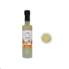 Bottle of peach-flavored white balsamic vinegar with a close-up of the liquid on a white background.