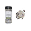 Jar of cranberry and rosemary spice brine with scattered spices on a white background