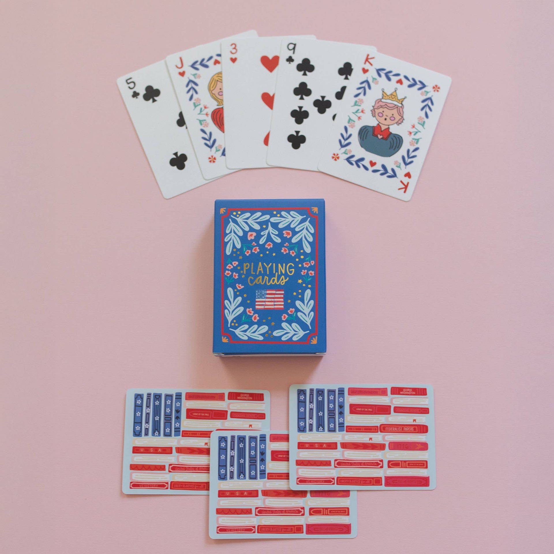 Playing cards with decorative designs on a pink background