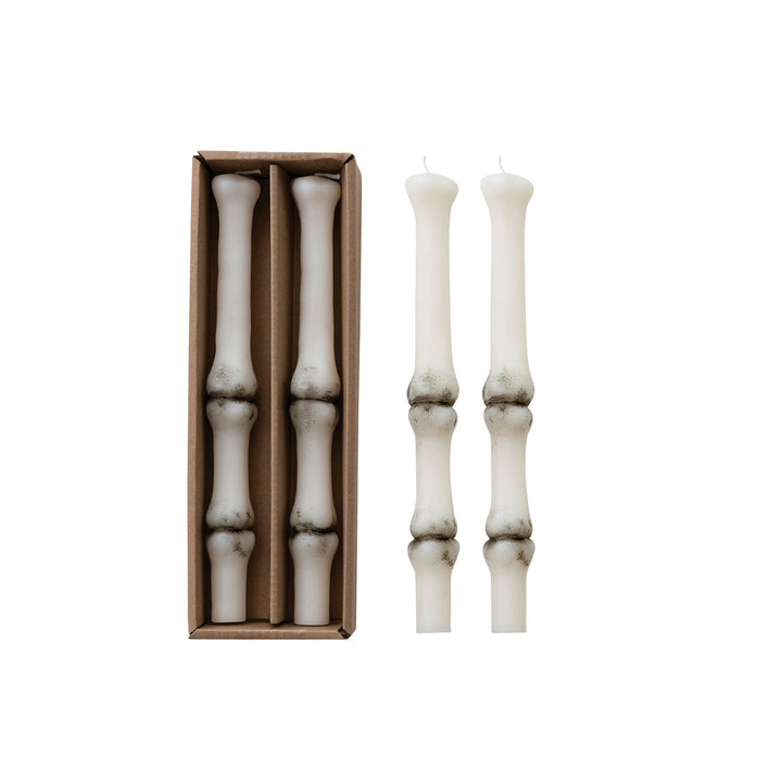 Set of white candlesticks with a cardboard box on a white background
