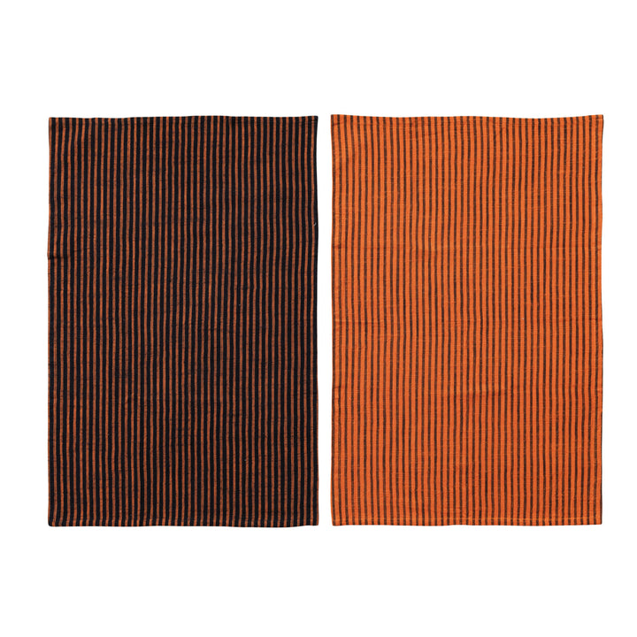 Two rectangular kitchen towels, one brown with thin orange stripes and one orange with thin black stripes, on a white background.
