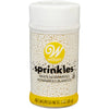 Bottle of Wilton white nonpareils sprinkles on a white background
