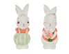 Two rabbit shaped salt and pepper shakers with orange dresses on a white background