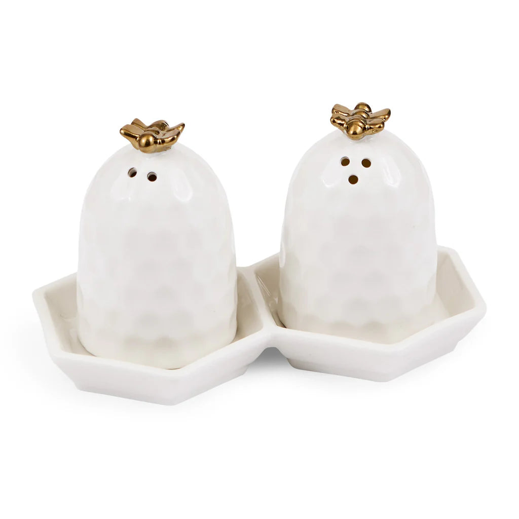 White beehive salt and pepper shakers with gold bees on a matching tray.