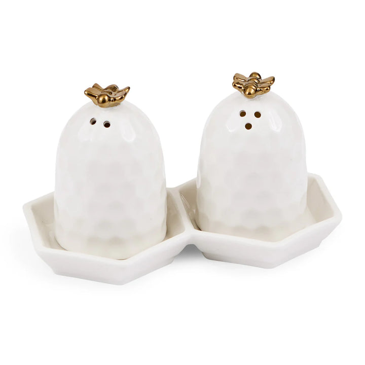 White beehive salt and pepper shakers with gold bees on a matching tray.
