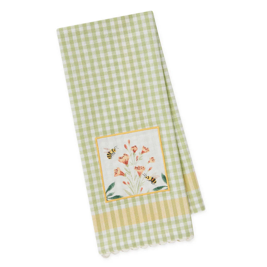 Green and white checkered towel with floral and bee design on a white background