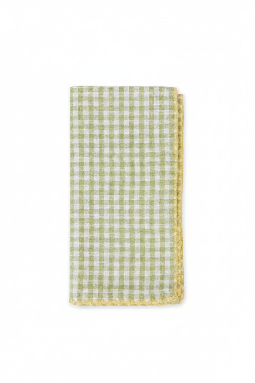 Green and white checkered napkin with a decorative edge on a white background