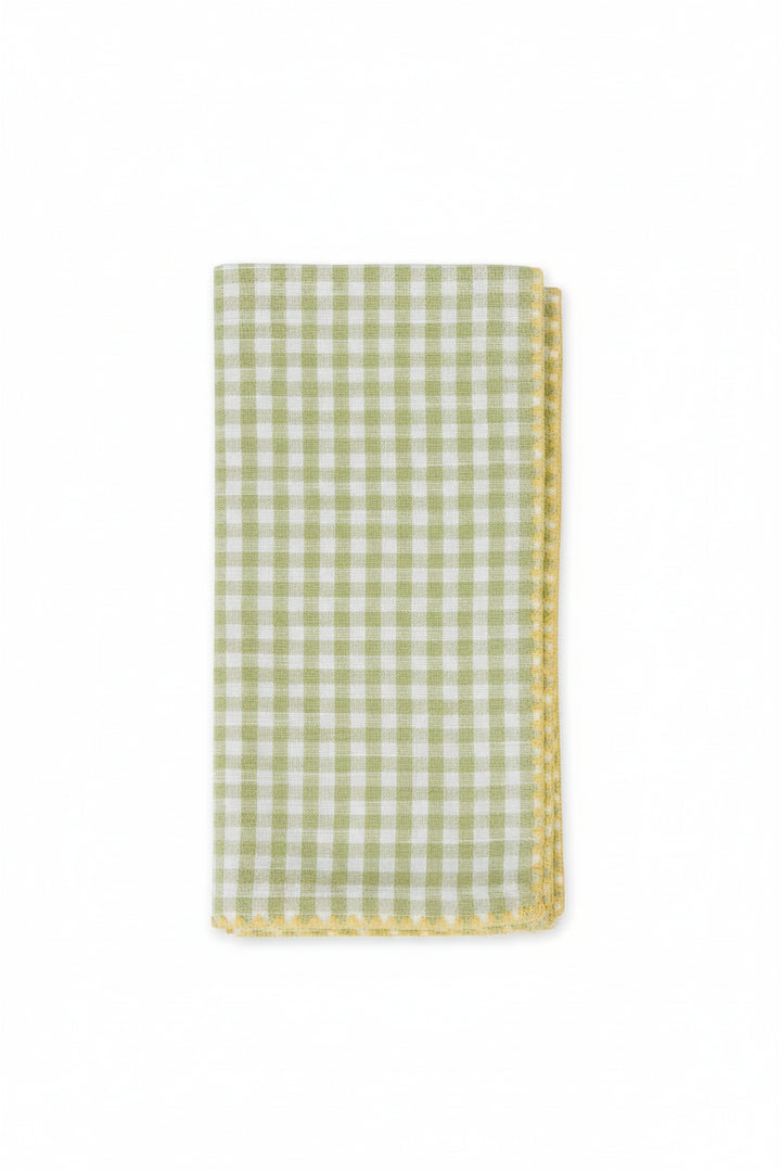 Green and white checkered napkin with a decorative edge on a white background