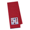 Red towel with white floral pattern and blue and red star design. Towel is on a white background