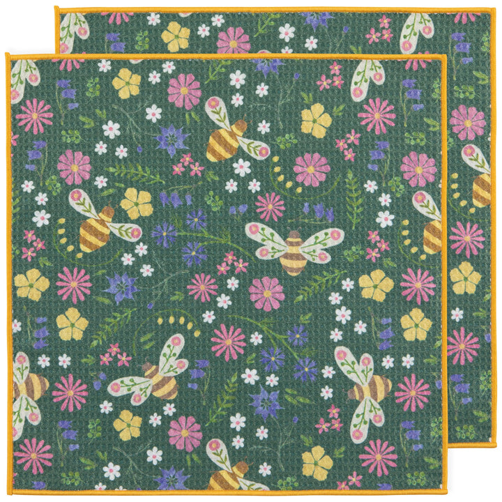 Floral and bee patterned dish cloths with colorful flowers and bees on a green background.