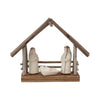 Small nativity scene with three figures and a wooden shelter on a white background