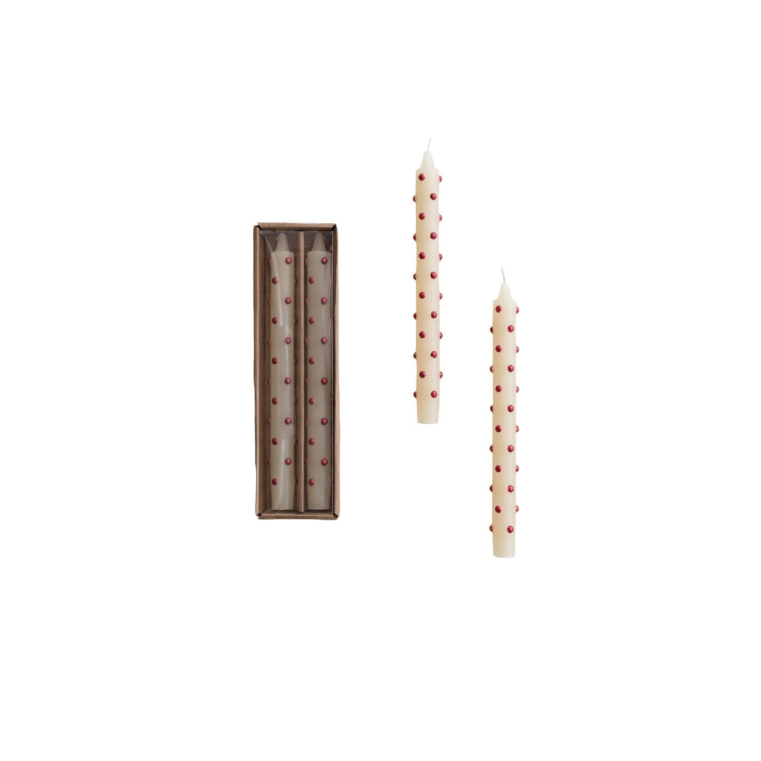 Two tall, tapered candles with red dot patterns next to their packaging on a white background