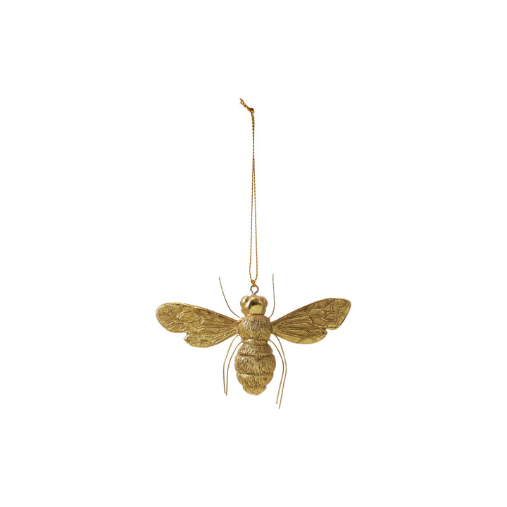 Gold bee-shaped ornament hanging on a white background