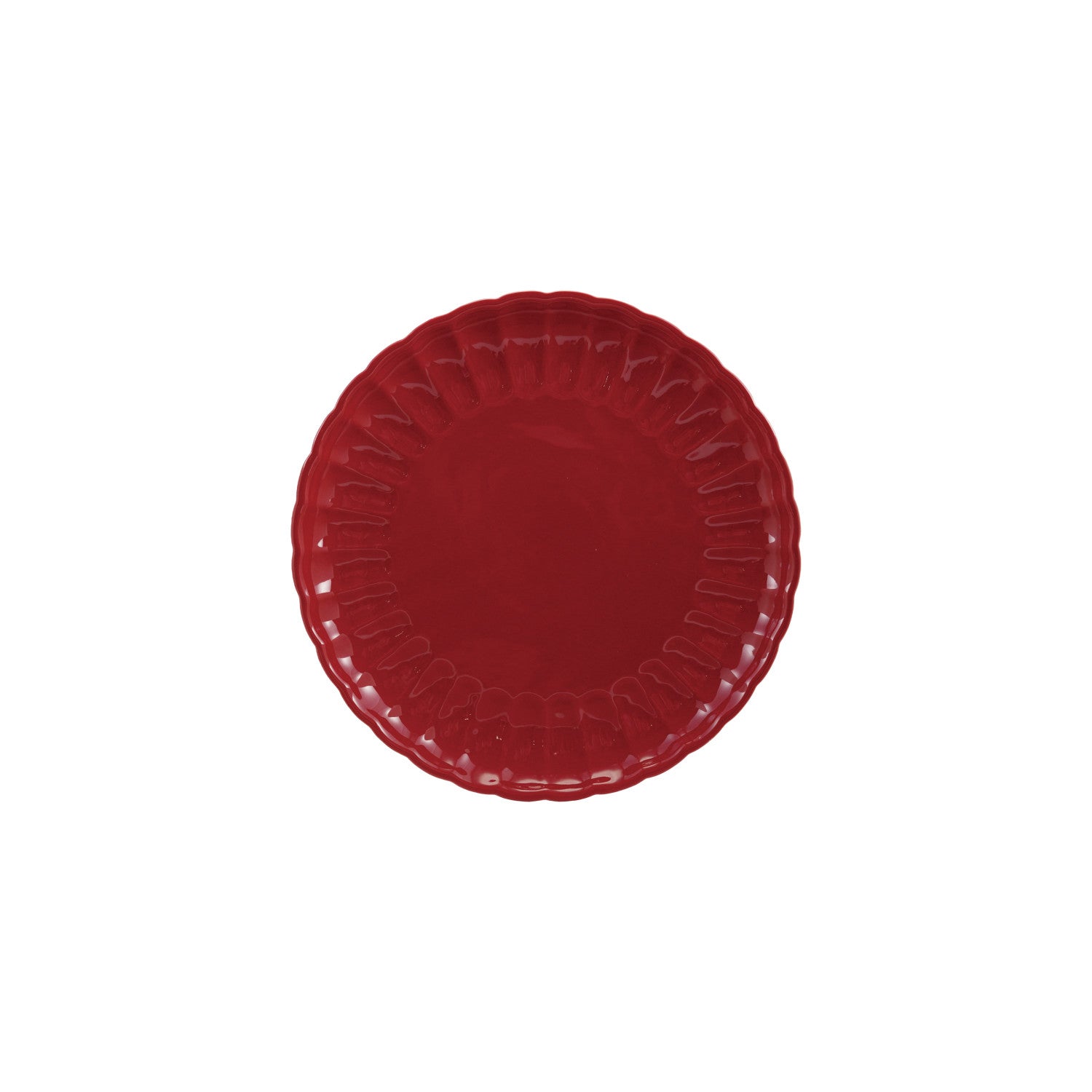 Red stoneware plate with scalloped edge on a white background