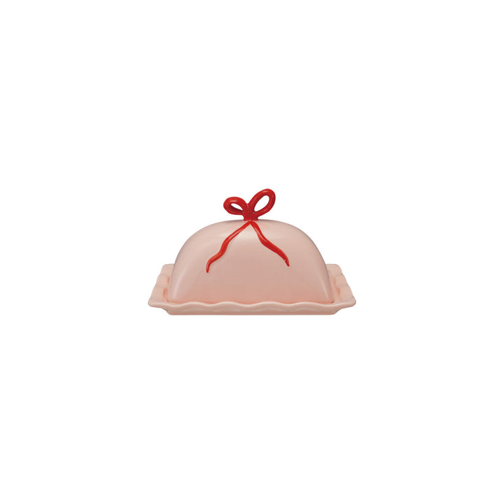 Pink butter dish with a red bow on a white background